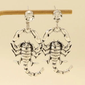 Close-up of retro silver scorpion earrings with sparkling crystal rhinestones set on metal