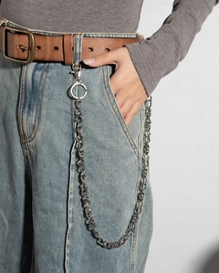 Silver skull chain on blue jeans featuring punk metal links and spring clasps for hip-hop style