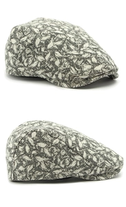 Detailed side view of a vintage flat cap with grey and white abstract leaf patterns