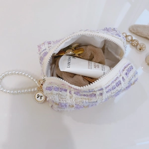 Elegant lavender tweed small handbag with pearl handle and bow pendant on white surface