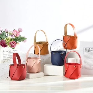 Variety of colorful mini PU leather wedding gift buckets on white geometric pedestals