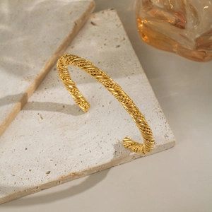 Close-up of twisted gold texture on an 18K gold plated stainless steel cuff bracelet