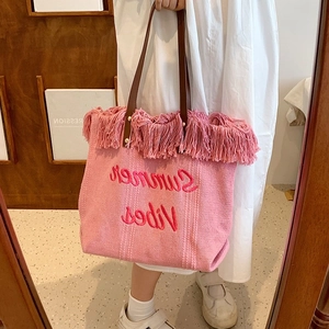 Detail of pink canvas tote with Summer Vibes embroidery and fringe tassels
