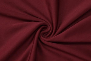 Nahaufnahme des eleganten burgunderroten Strickstoffs mit Falten und seidigem Fall