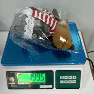 Detail showing weight of Christmas plush reindeer doll on a digital scale at 199.5g
