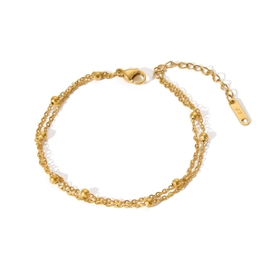 Macro shot of 18k gold plated stainless steel layered chain bracelet with metal beads