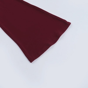 Détail du tissu tricoté bordeaux montrant les coutures nettes de la manche et sa texture
