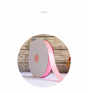 Macro detail of high-luster pink satin ribbon roll for gift wrapping and cake decoration
