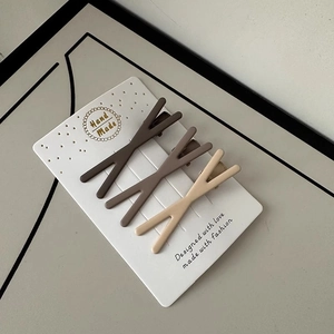 Three-piece matte seamless hair clips in coffee and cream tones on a white display card