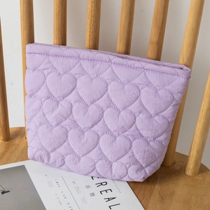 Detailed texture of purple heart quilted nylon fabric pouch on a wooden chair