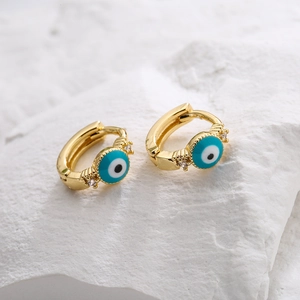 18K gold evil eye huggie earrings with blue enamel and zircon on a textured stone base