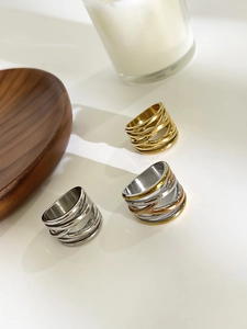 Detailed view of layered crossover rings in gold, silver, and rose gold finishes