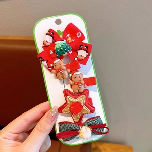 Detail view of Christmas hair clips featuring festive snowman and star motifs on card