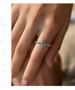 Close-up of s925 silver ring featuring a round blue opal center and halo diamond setting