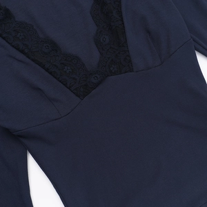 Detailed close-up of navy blue ribbed knit fabric with delicate black lace V-neck stitching