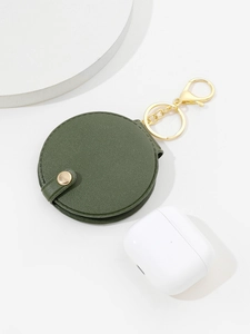 Macro shot of green round PU leather mirror keychain with gold hardware and snap button