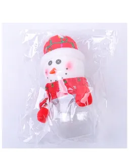 Close-up of a Christmas snowman candy jar in packaging with a red knitted scarf and hat