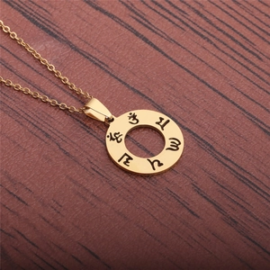 Gold stainless steel circular hollow pendant necklace with engraved mystic symbols on wood