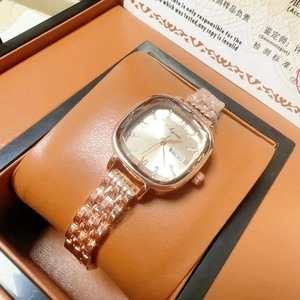 Detailed view of women's rose gold square watch with crystal markers and day-date display