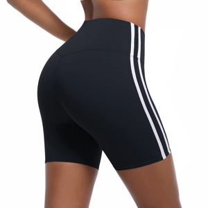 Detail view of high-waisted black yoga shorts with white side stripes and lifting effect