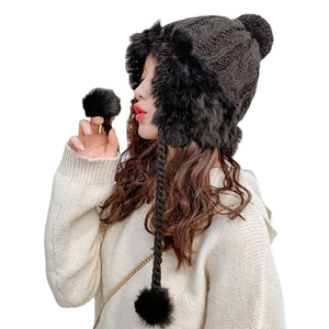 Women's black knitted trapper hat with faux fur lining and cute hanging pom-poms