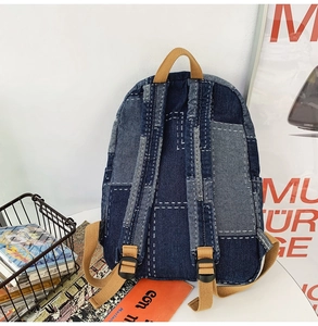 Rear view of patchwork denim backpack showing adjustable straps and stitching details