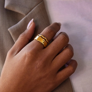 Macro view of 18k gold plated stainless steel wavy stackable rings on hand
