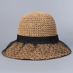 Close-up of beige woven straw hat featuring black mesh lace and polka dot ribbon detail