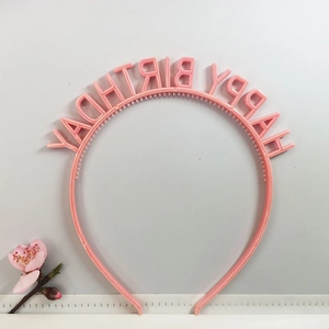 Detail of pink Happy Birthday plastic headband with molded lettering for party accessories