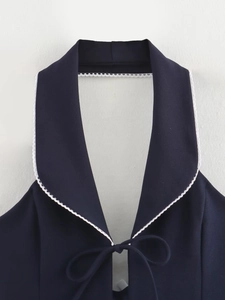 Détail du haut dos nu bleu marine avec bordure en dentelle blanche et petit nœud frontal