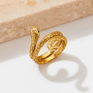 Bague serpent dorée avec texture d'aspect enroulé avec texture d'écailles sur fond de pierre neutre