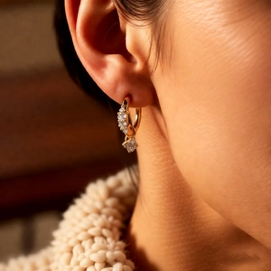 Gros plan d'une boucle d'oreille fleur en zircon doré avec pendentif étoile sur mannequin