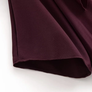 Macro view of the wine red knitted fabric texture and precise stitching on the hemline