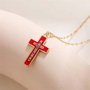 Detail showing the red enamel finish and colorful zircon inlay on the golden cross pendant