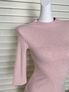Detail of pink ribbed knit texture and padded shoulder design on a slim fit dress