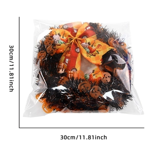Macro shot of a 30cm Halloween tinsel wreath with orange pumpkins and a plaid bow