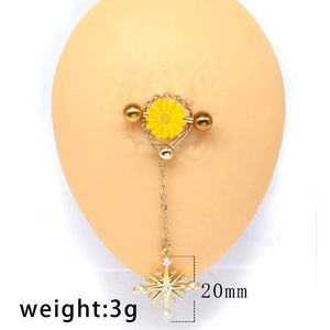 Detailed close-up of golden nipple ring with yellow flower and rhinestone star charm