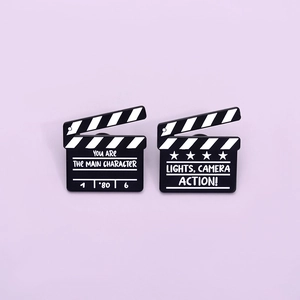 Cartoon movie clapperboard enamel pins set with Lights Camera Action typography