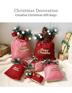 Detail of red buffalo plaid Christmas gift bags with pine cones and berries decoration