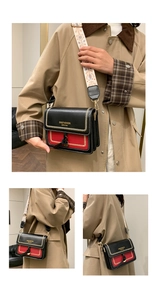 Detail of red and black crossbody bag with white stitching and ethnic patterned strap