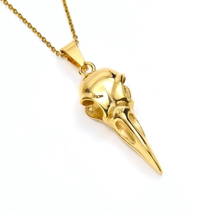 Detailed view of a gold bird skull pendant necklace with intricate metal textures