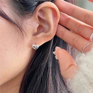 Silver 925 heart stud earrings with lattice texture shown worn on earlobe