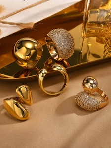 Exquisite set of five gold-plated rings displayed on a luxurious satin champagne background