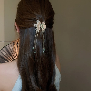Detail of floral hair clip with gold tassels and green beads for traditional style