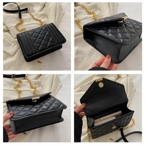 Detail view of black quilted chain bag with gold hardware and internal storage capacity