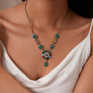 Detailed view of vintage bronze flower necklace with colorful crystal pendant on neck