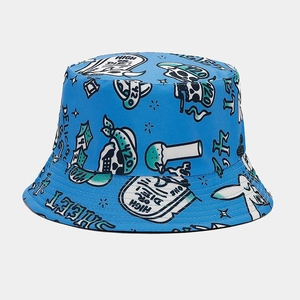 Detail of blue canvas bucket hat featuring skull graffiti prints and streetwear typography