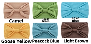 Detail view of elastic yoga headbands in camel, green, blue, and yellow knitted fabric