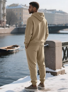 Close-up of men's thermal waffle knit hoodie and jogger set in warm beige outdoors