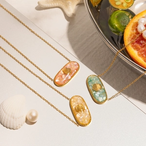 Elegant macro view of ocean style oval shell pendants with golden embossed shell motifs